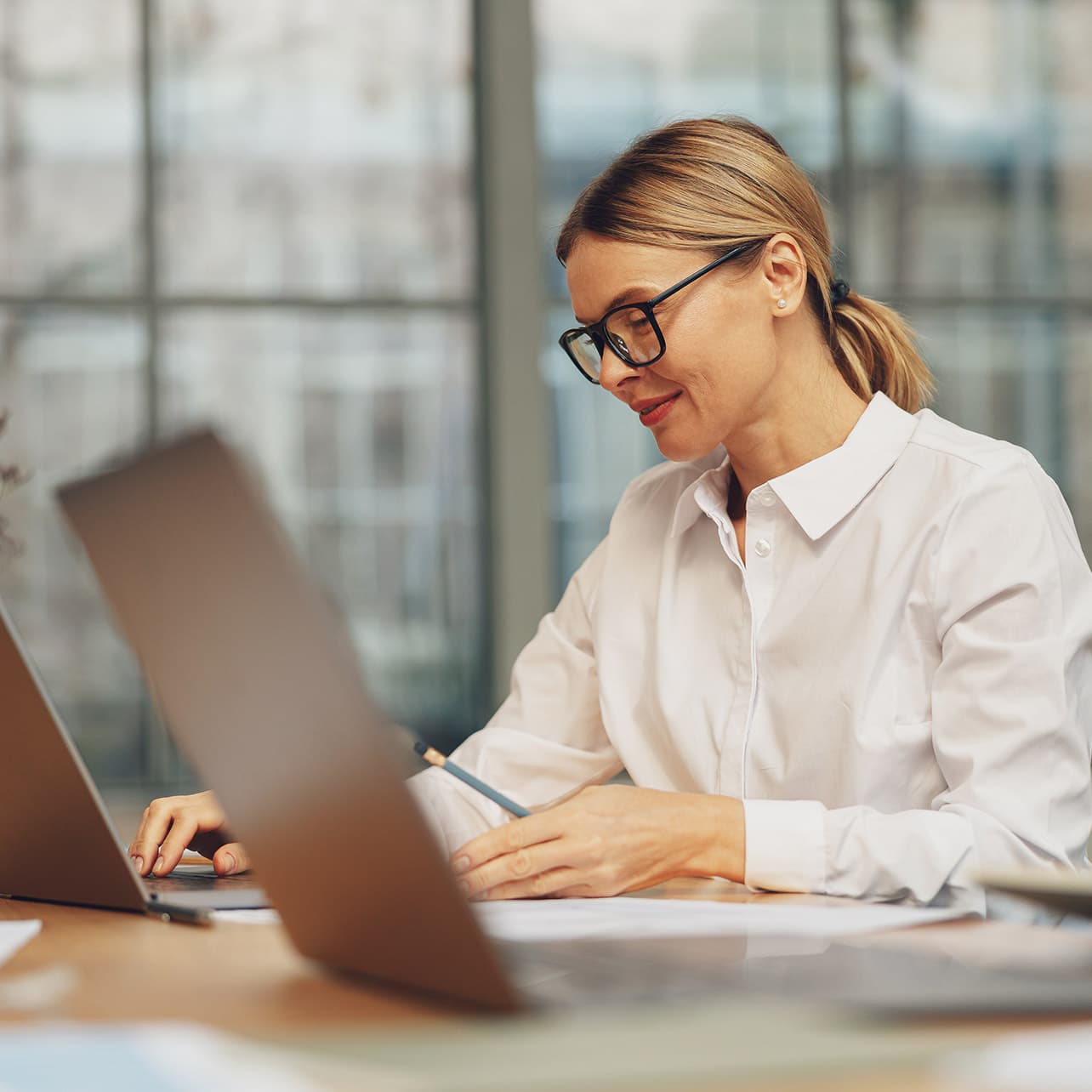A person in a blue shirt is working on a laptop, with an activity graph and financial summary displayed alongside their profile as "Shannon, IT."
